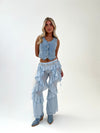 Woman wearing a denim outfit with layered pants on a white background