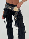 Black ruffled pants with gold embellishments on a white background