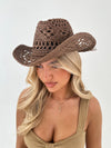 woman wearing a brown cowboy hat on a white background