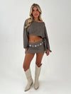 woman in a stone outfit with beige boots and silver belt