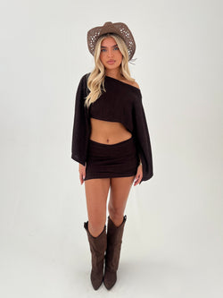 woman in a chocolate brown outfit with chocolate brown boots and hats