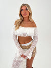 Lady in white top and skirt with a beige belt on a white background