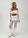 woman in a white outfit with white hat and gold belt on a white background