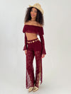 woman in a burgundy outfit with gold hat, belt and boots
