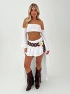 woman in white outfit with burgundy belt and boots