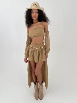 Woman wearing a camel outfit with a hat on a white background