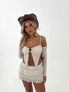 Woman wearing a lace outfit with a brown hat on a white background