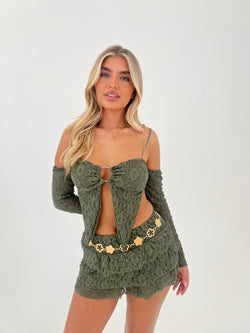 Woman wearing a green lace outfit with cut-out design on a white background