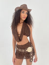 woman in brown lace outfit with brown hat and belt