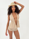 Woman wearing a striped outfit and straw hat on a white background