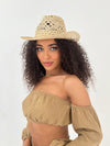 Woman wearing a straw hat and beige top on a white background